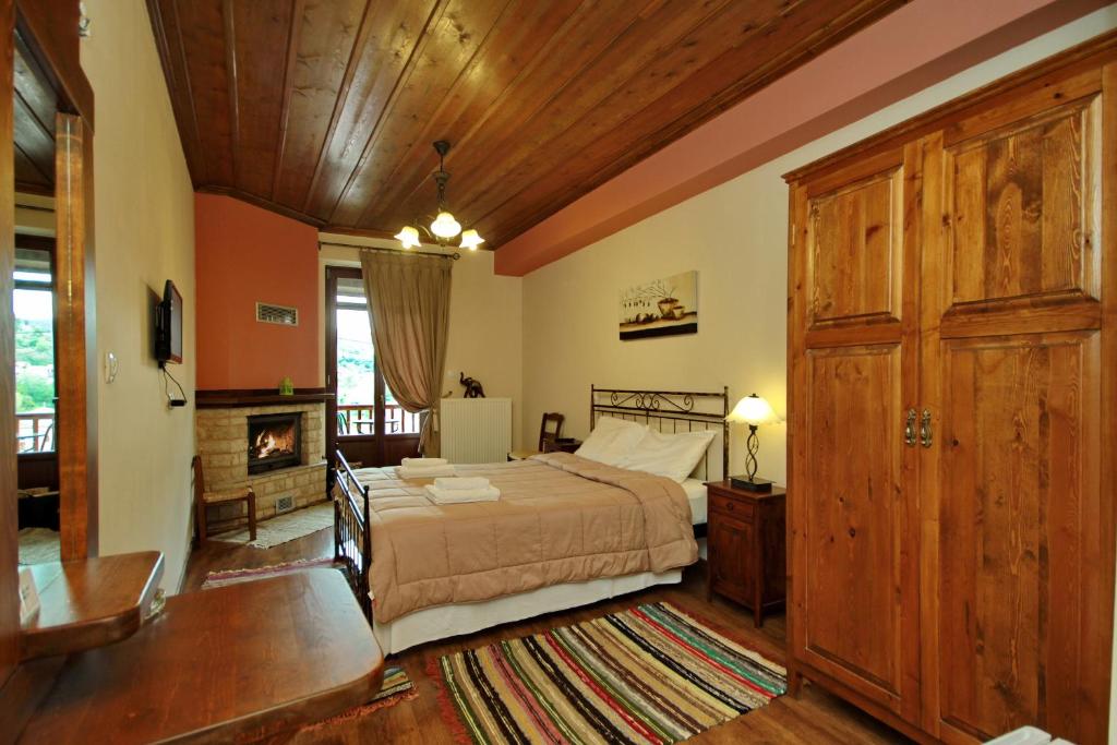 a bedroom with a large bed and a fireplace at Thea Valtessinikou in Valtessiniko