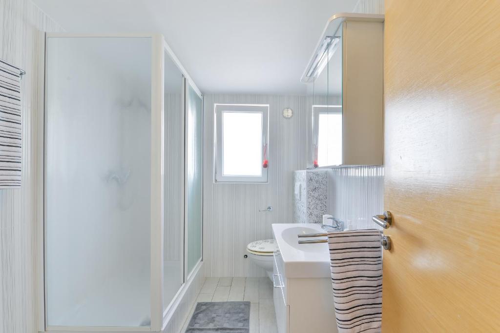 ein Badezimmer mit einem weißen WC und einem Waschbecken in der Unterkunft Apartments with a parking space Vir - 18581 in Vir
