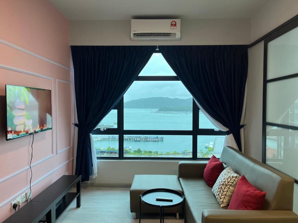 a living room with a couch and a large window at Splendours Condos@Jesselton Quay in Kota Kinabalu