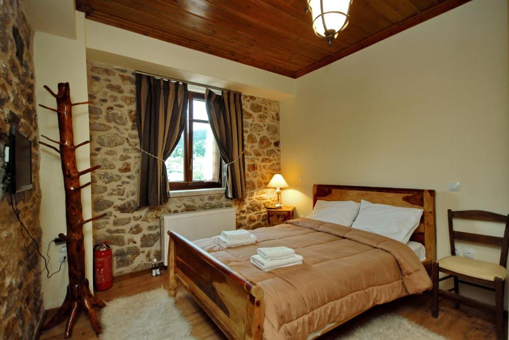 una camera da letto con un letto, una sedia e una finestra di Thea Valtessinikou a Valtessiniko