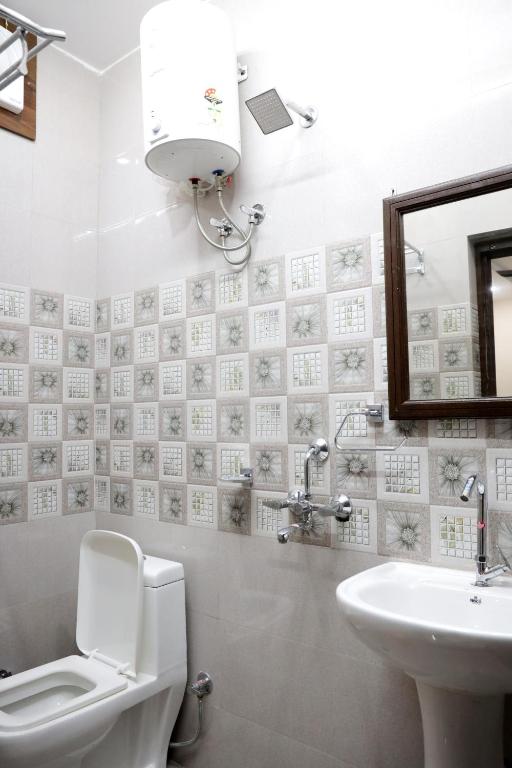 y baño con aseo, lavabo y espejo. en Hotel Ajeet Palace, en Jaisalmer