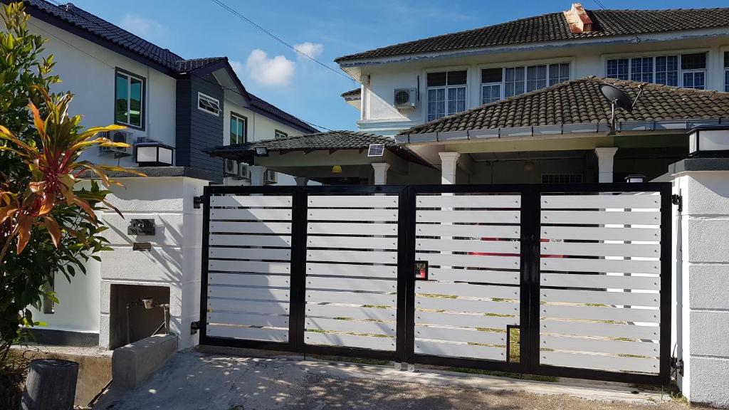 a white gate in front of a house at RR Homestay Lot 144 Chukai Kemaman in Cukai