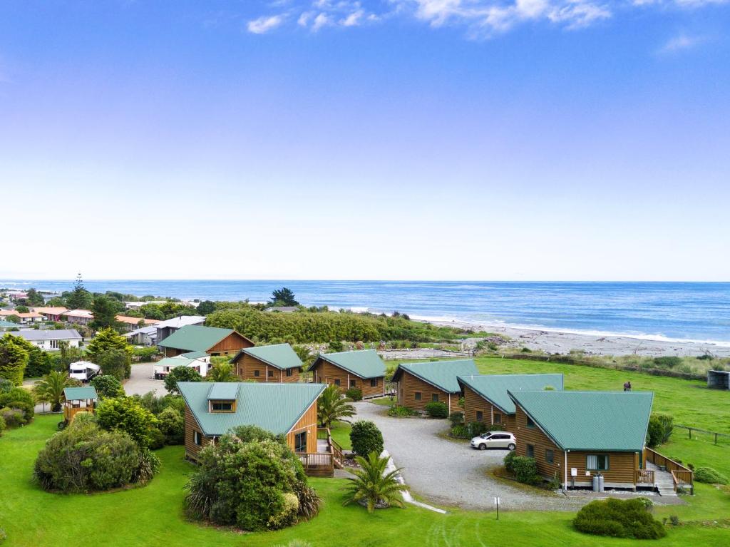 eine Luftblick auf einen Strand mit Häusern und das Meer in der Unterkunft Shining Star Beachfront Accommodation in Hokitika