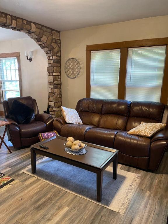 a living room with a leather couch and a coffee table at Sherman Hill Des Moines in Des Moines