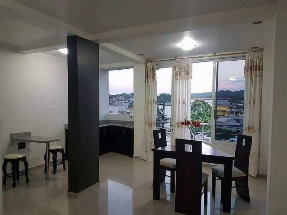 comedor con mesa y sillas y ventana grande en Conjunto Habitacional EspinBarroso, en Puyo