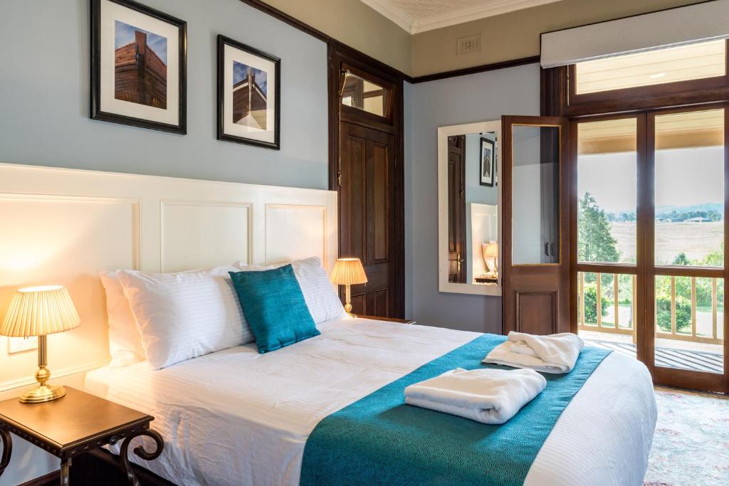 ein Schlafzimmer mit einem großen Bett mit blauen und weißen Kissen in der Unterkunft Kings nd Queens Paterson in Paterson