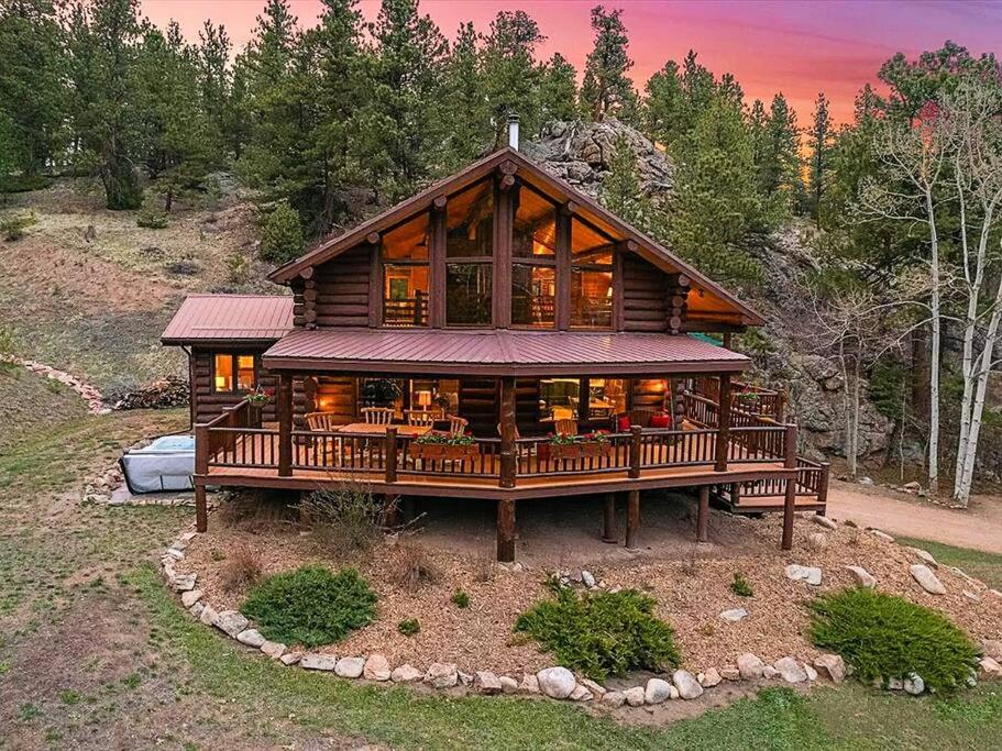 a large wooden house on a hill with trees at Classic Log Cabin near Rocky Mountain National Park and near Skiing in Lyons