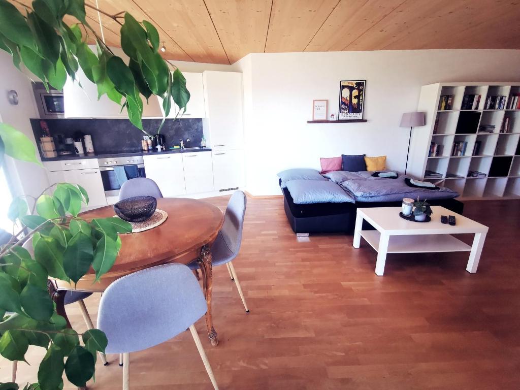 uma sala de estar com uma mesa e um sofá em Ferienwohnung Heimatliebe mit Alpenblick em Weilheim