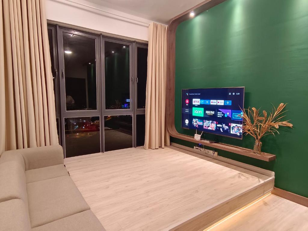 a living room with a couch and a large window at One Bedroom Troika Kota Bharu by AGhome in Kota Bharu