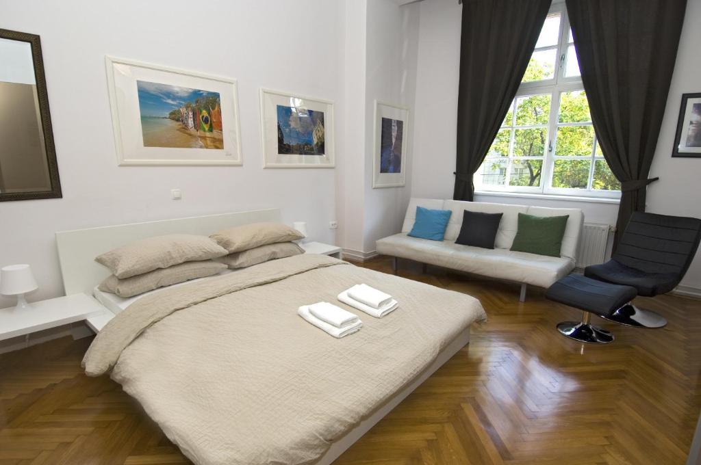 a bedroom with a bed, a desk and a painting on the wall at Galeria Rooms in Ljubljana