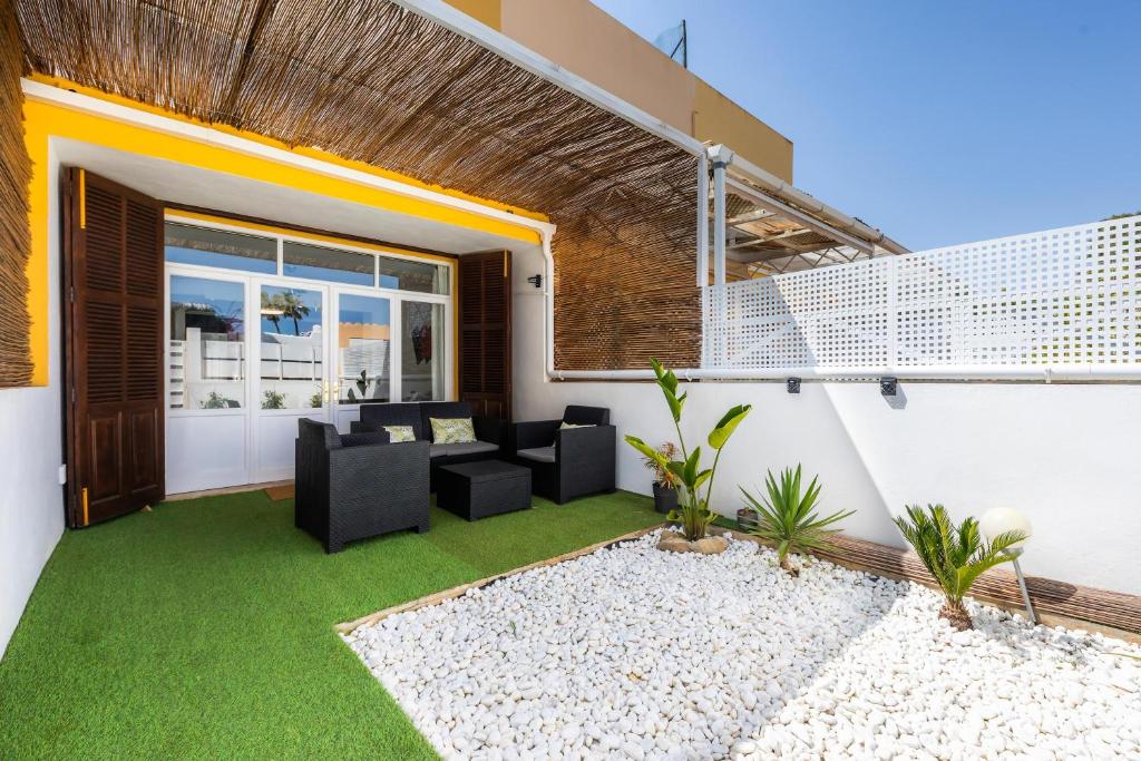 an outdoor patio with green grass and black chairs at Dolce Vita in Alcudia
