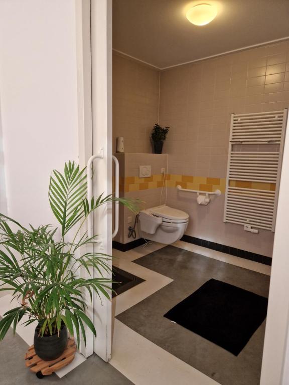 a bathroom with a toilet and a plant in it at De Remise in Hengelo
