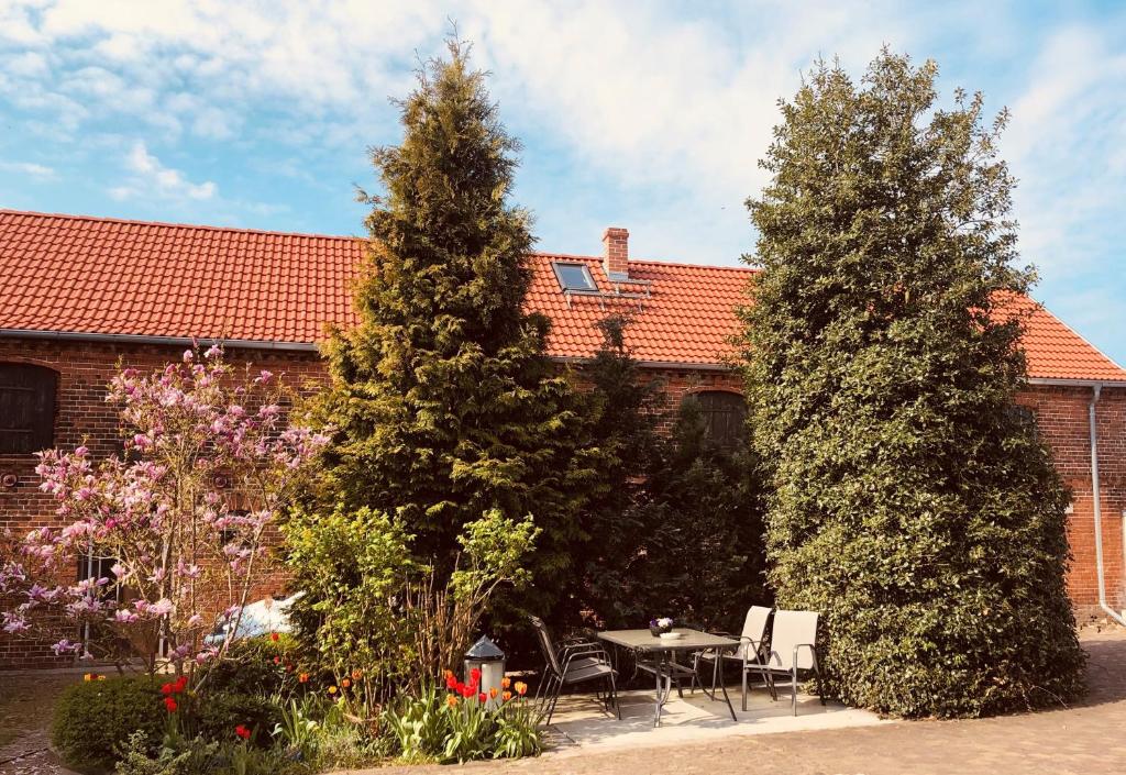 um jardim com duas árvores e uma mesa e cadeiras em Ferienwohnung Steckelsdorf em Rathenow