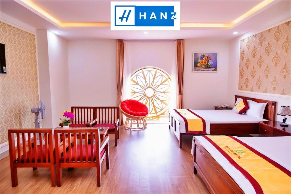 una habitación de hotel con 2 camas y una silla en HANZ Bao Long Hotel, en Ho Chi Minh