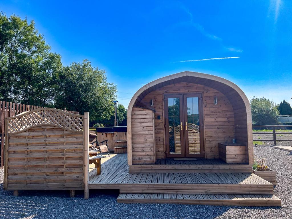 a small wooden cabin with a wooden deck at Bryn Glamping in Coychurch