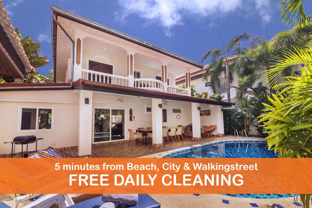 a villa with a swimming pool and an orange banner at Villa Waree 5 minutes from Beach and Walking street in Pattaya South