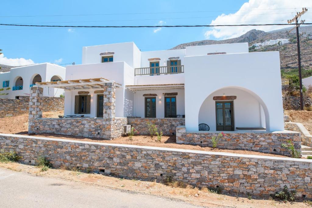 una casa al lado de una pared de piedra en Araklos II, en Egíali