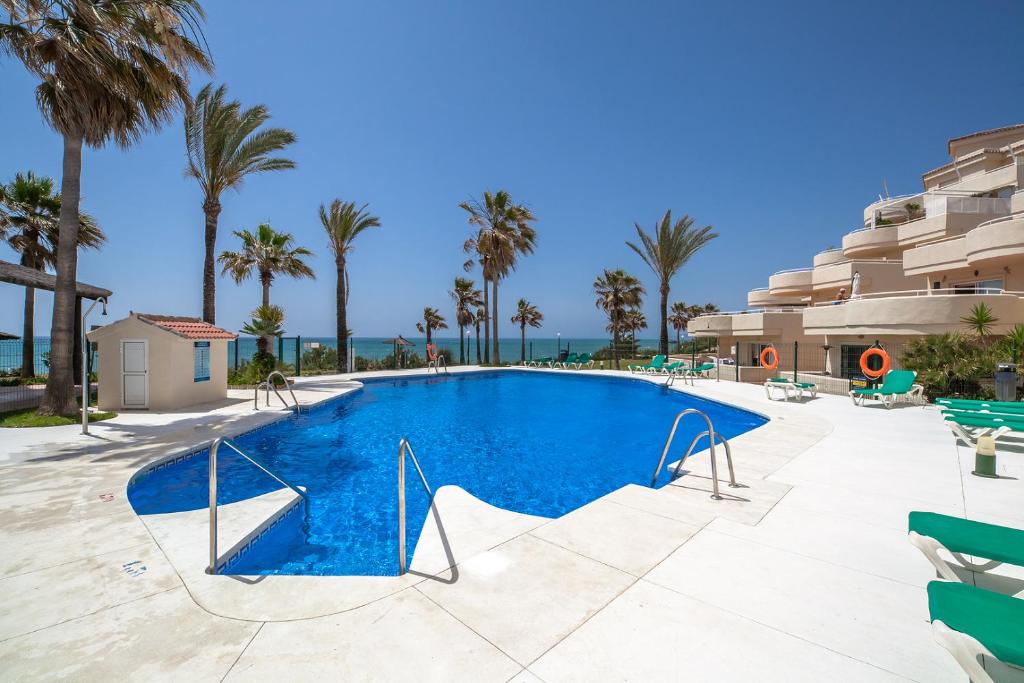 basen z palmami i budynek w obiekcie El Mirador de Estepona w mieście Estepona