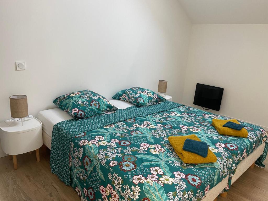 a bedroom with a bed with a green comforter at Duplex près de Nantes in Thouaré-sur-Loire