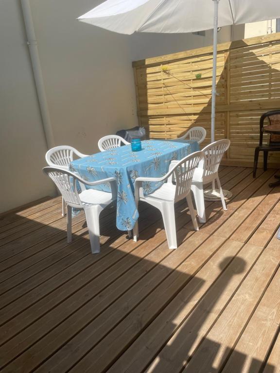 a blue table with chairs and an umbrella on a deck at Duplex près de Nantes in Thouaré-sur-Loire