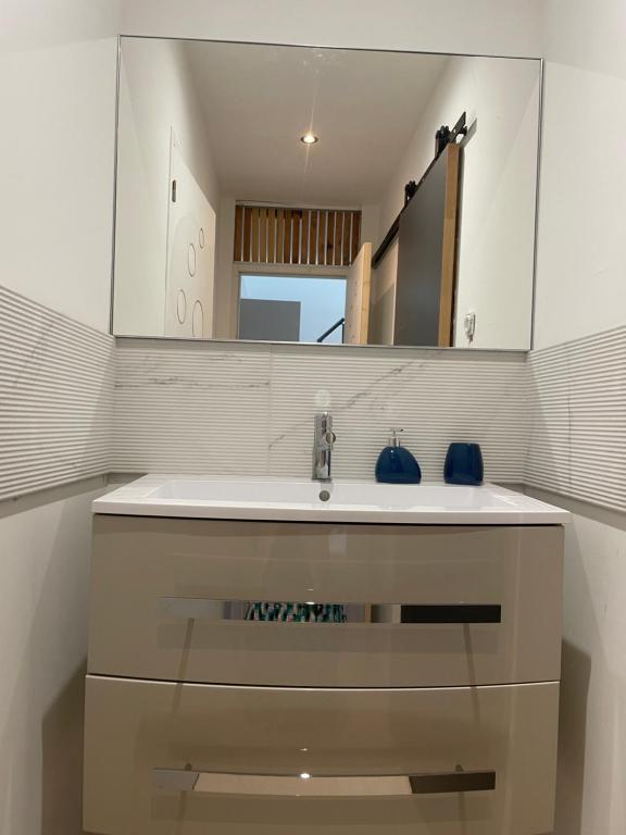 a bathroom with a sink and a mirror at Duplex près de Nantes in Thouaré-sur-Loire