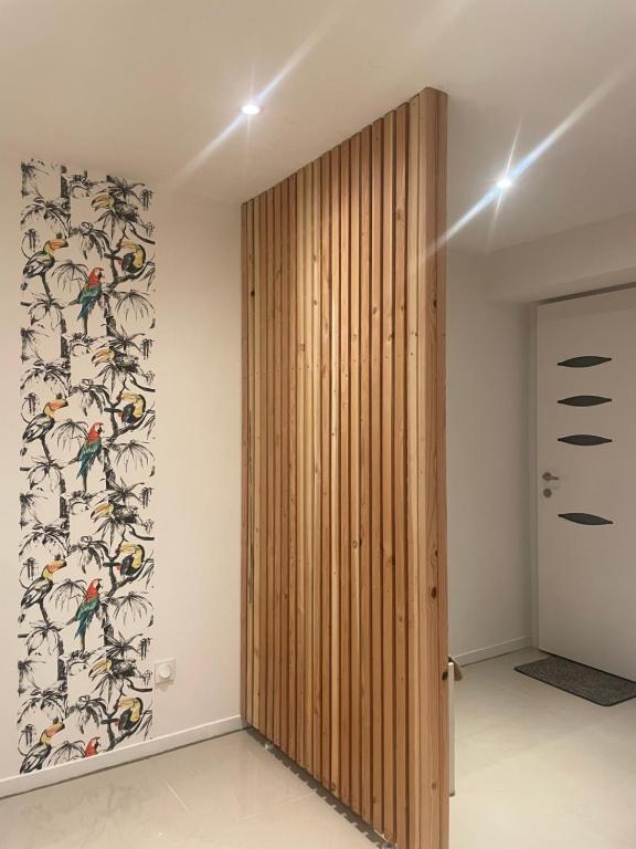 a wooden door in a room with a wallpaper at Duplex près de Nantes in Thouaré-sur-Loire