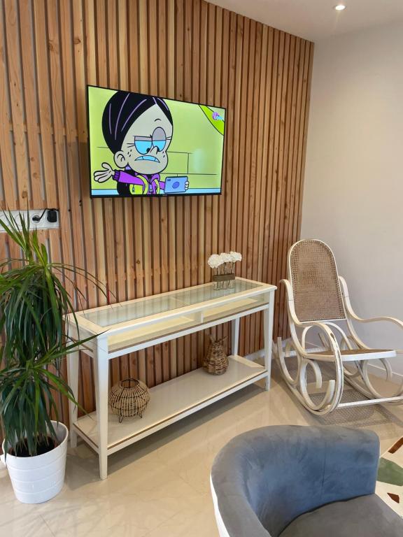 a living room with a tv on a wall at Duplex près de Nantes in Thouaré-sur-Loire