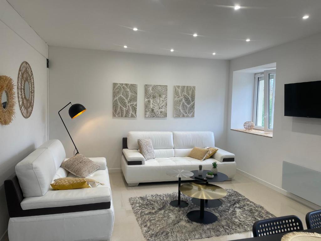 a living room with two white couches and a tv at Duplex près de Nantes in Thouaré-sur-Loire