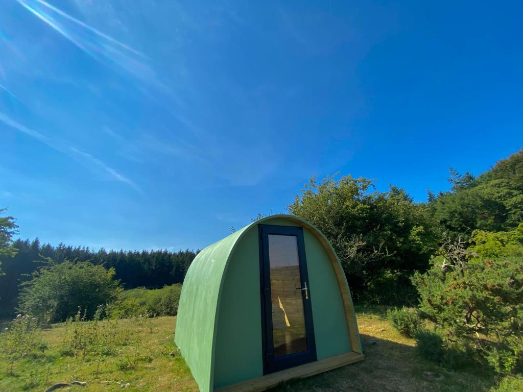 a green dome house in the middle of a field at Lakeside Eco Pod in Oswestry