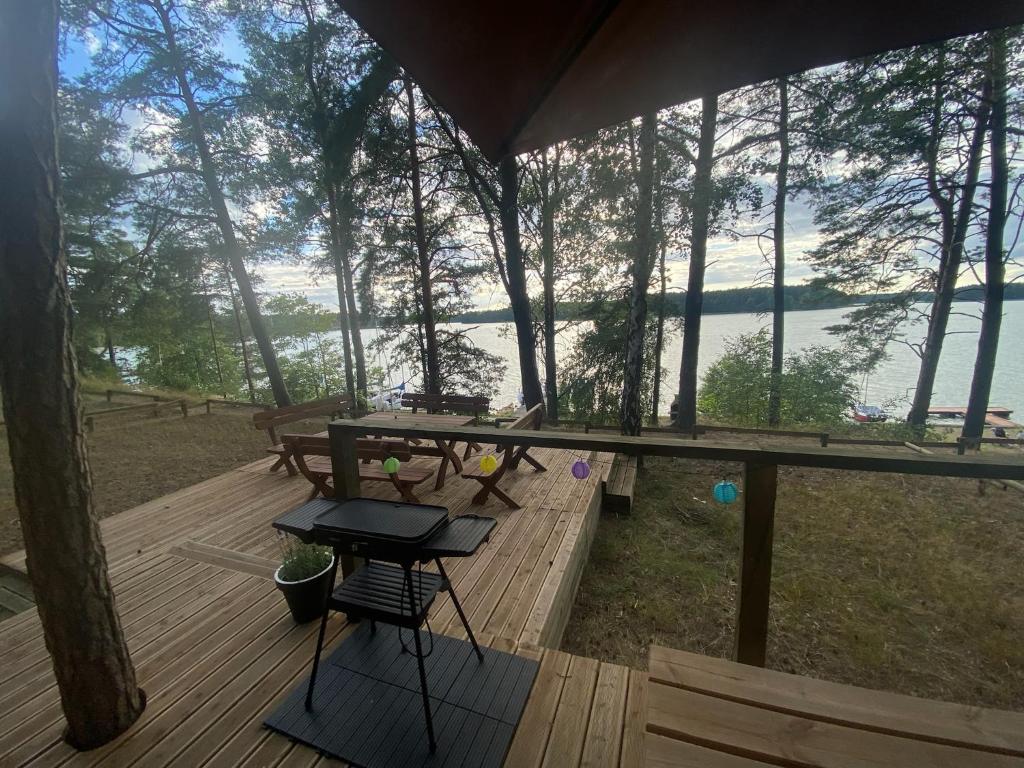 une terrasse en bois avec une table de pique-nique et une vue sur le lac. dans l'établissement Kaszub, à Borsk