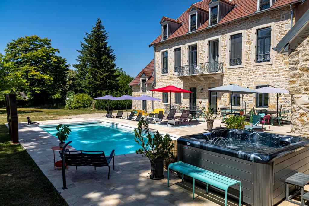 a swimming pool in front of a house at Le 49 Côté Parc & SPA in Domblans