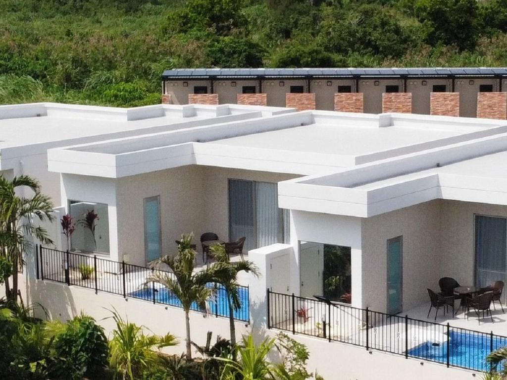 a large white building with a swimming pool at -Villa Rikyu- 離宮 in Miyako Island