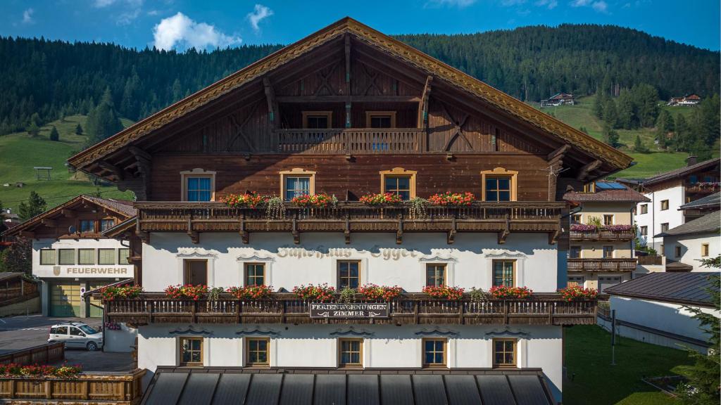 a building with a balcony with flowers on it at Haus Egger in Kartitsch