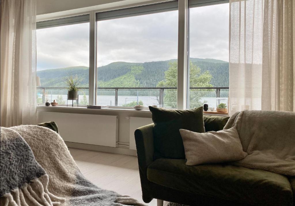 a living room with a couch and a large window at Åre Travel - VM huset in Åre