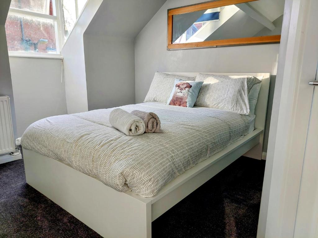 a small bedroom with a white bed with a window at The York Riverside Suites in York
