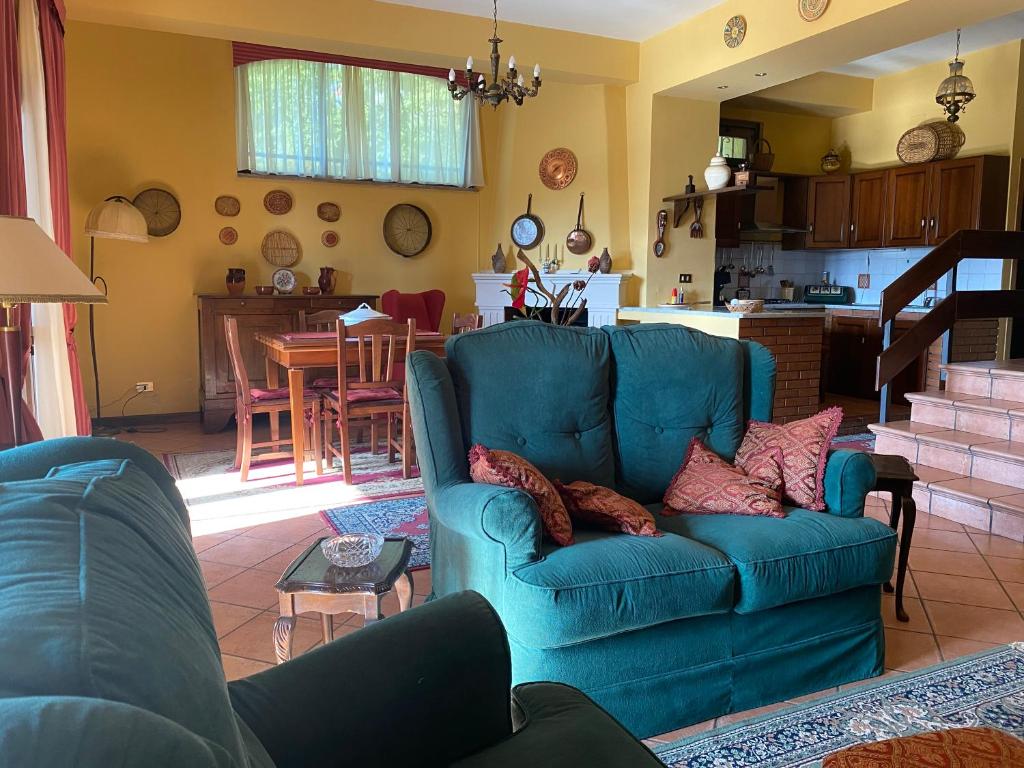 a living room with a blue couch and a kitchen at A casa di Tina in Mendicino