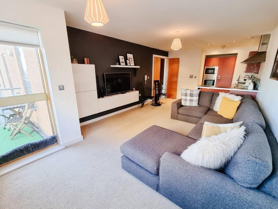 un soggiorno con divano blu e un soggiorno con cucina di Luxury City Centre Home With Free Secure Parking a Stalybridge