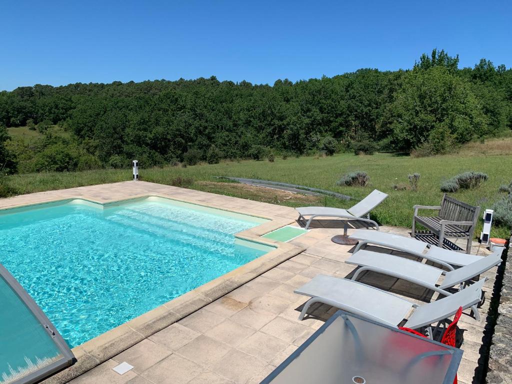 einen Pool mit 2 Liegestühlen und einem Pool in der Unterkunft Gîte à la Ruelle "Pierre et Mamie" ! in Savignac-de-Miremont