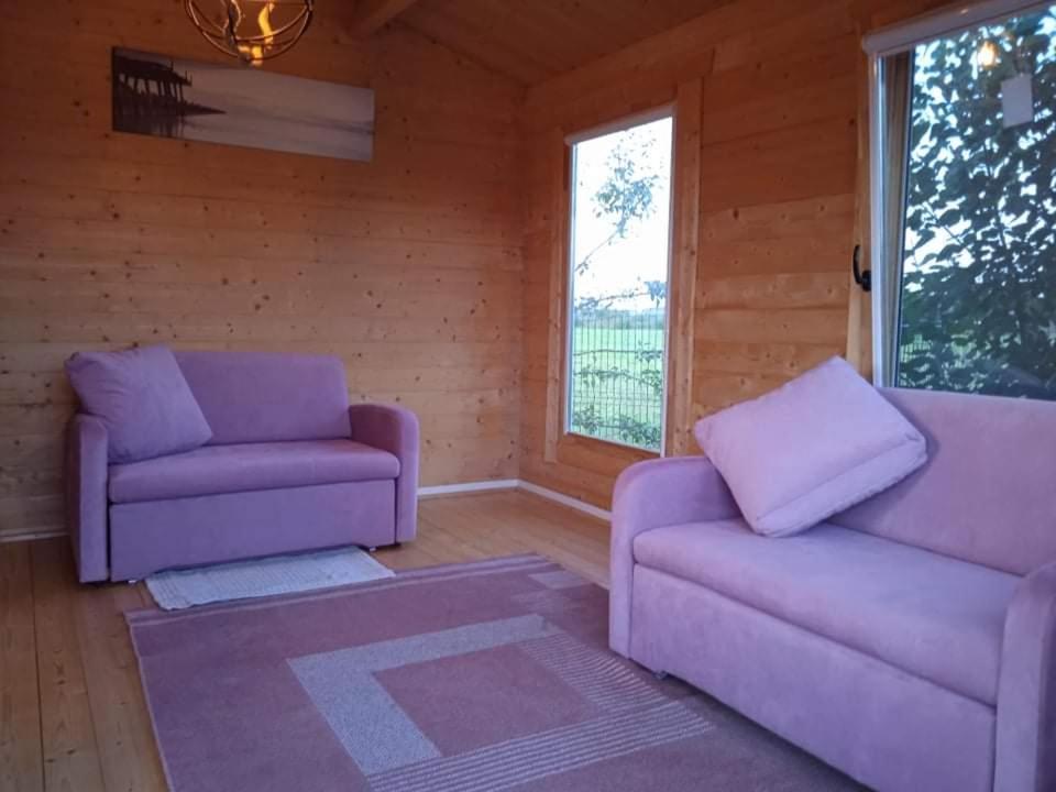 un soggiorno con divani viola e una finestra di Namelis Karklėje a Karklė
