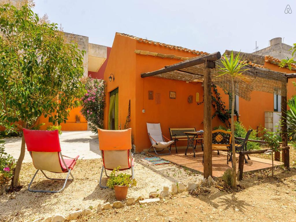 a patio with chairs and a table in front of a house at Appartamenti Fior Di Loto in Trapani
