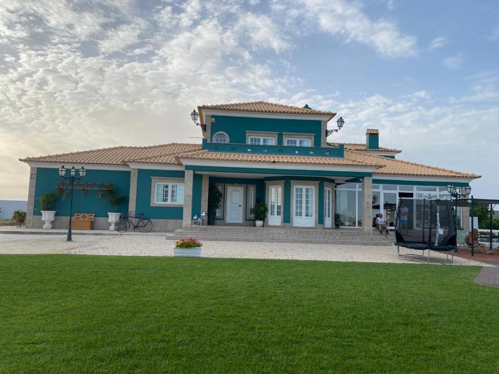 uma casa azul com um relvado verde em frente em Quinta dos Filipes em Palmela