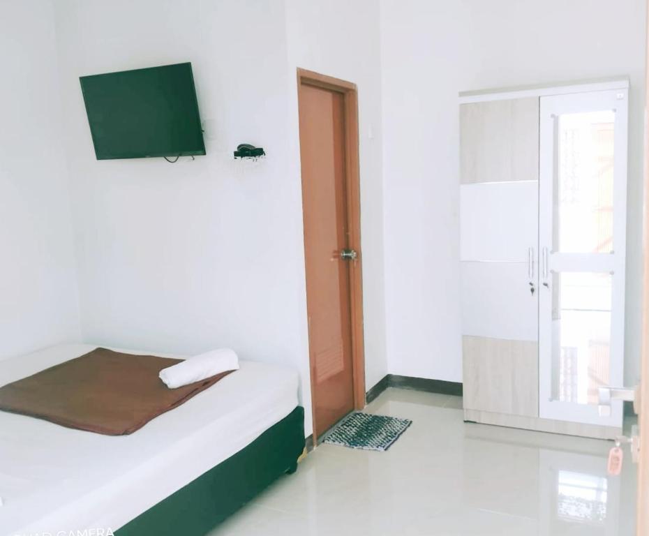 a bedroom with a bed and a tv on the wall at Nyenyak Senayan Benhil in Jakarta