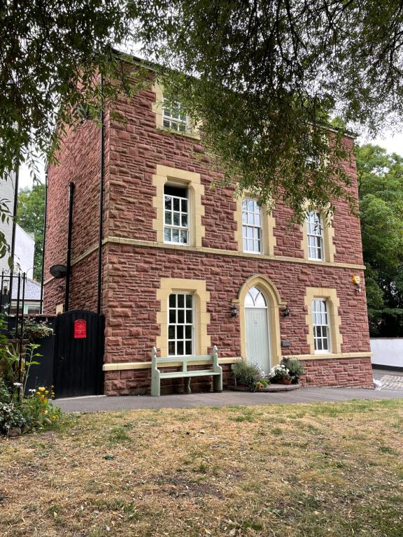 a brick building with a bench in front of it at Ty Llew Lodge in Abergavenny