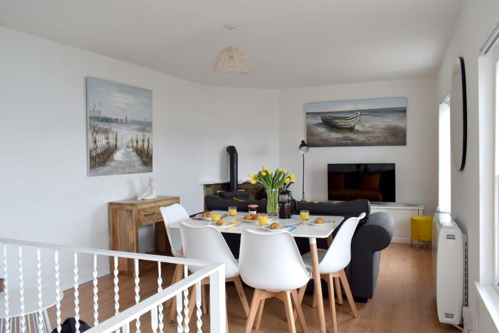 una sala da pranzo e un soggiorno con tavolo e sedie. di The Old Fishermans Lookout a Falmouth