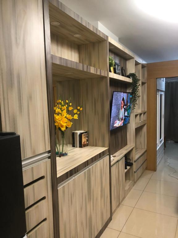 ein Wohnzimmer mit Holzwänden und einem TV in der Unterkunft Sea Residences JO Alano's Place in Manila