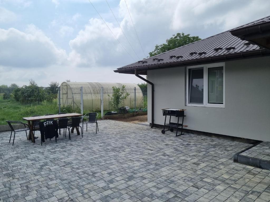 patio ze stołem i krzesłami obok domu w obiekcie Villa Akacjowa w mieście Turbia