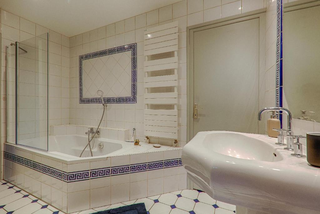 ein weißes Badezimmer mit einer Badewanne und einem Waschbecken in der Unterkunft La Ballerine - Baby foot - Centre historique in Romans-sur-Isère