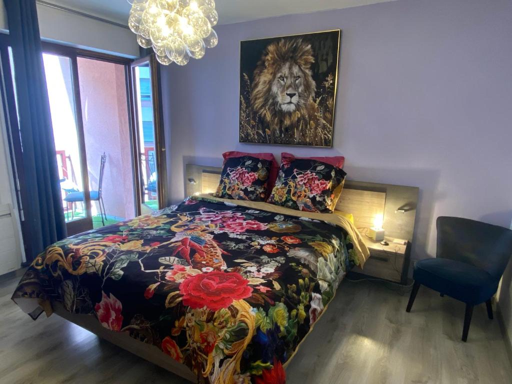 un dormitorio con una cama y una pintura de un león en Mallo's Lodge avec Parking GRATUIT et 2 balcons, en Colmar