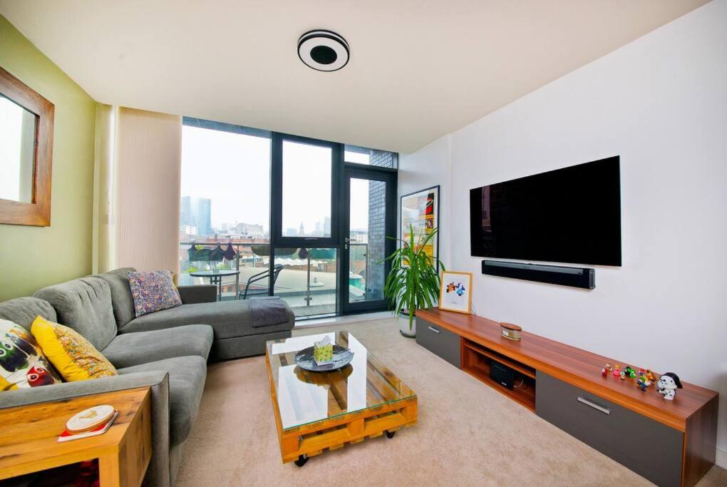 uma sala de estar com um sofá e uma televisão de ecrã plano em Free parking- Central water-side apartment em Flixton