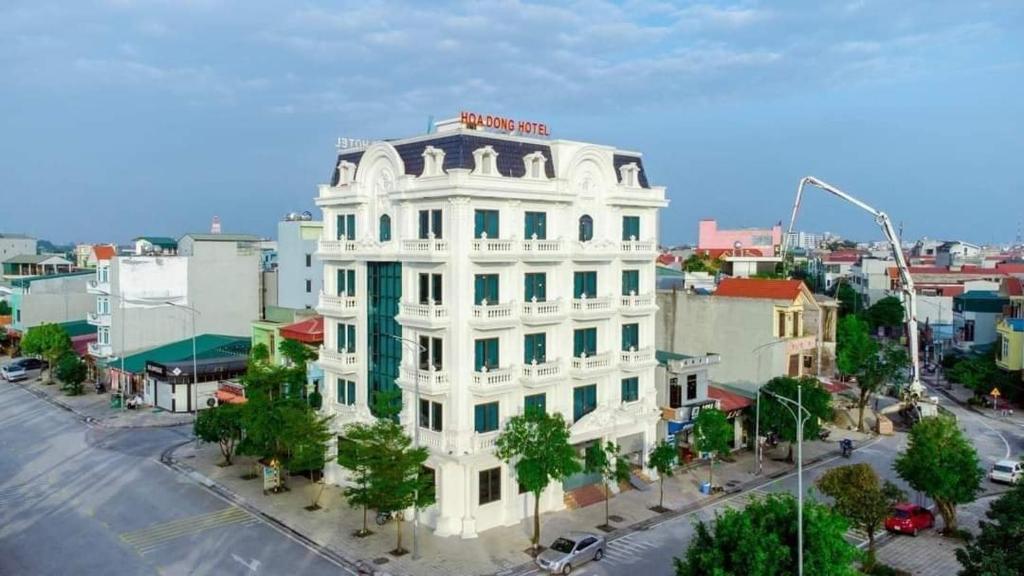 een wit gebouw met een rood bord erop bij Khách sạn Hoa Đông in Châu Cầu